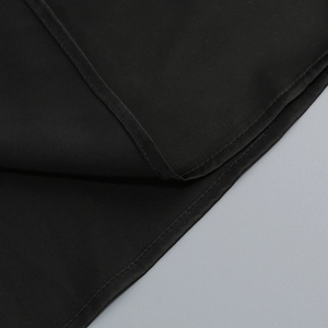 Macro view of meticulous stitching and smooth black fabric texture on the evening gown