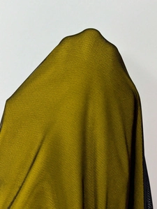 Detailed close-up of semi-transparent olive mesh fabric with a fine honeycomb texture