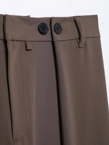Detail shot of brown trousers featuring double-button closure and fine twill fabric texture
