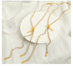 Detailed macro view of a gold zipper pendant necklace with sparkling crystal tassels