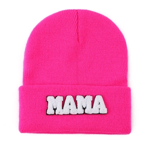 Detailed close-up of pink knit beanie with MAMA towel embroidery patch detail