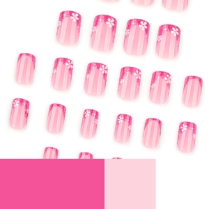 Pink French press-on nails with glitter tips and white flower designs on white background