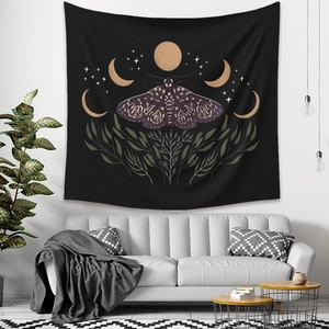 Bohemian black moth tapestry with moon phases and stars hanging above a grey sofa