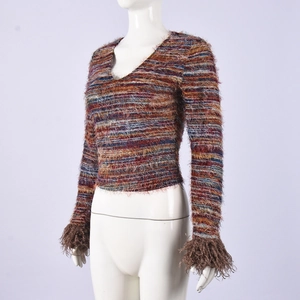Detail of colorful striped knit crop top with faux fur trim on sleeves and V-neckline