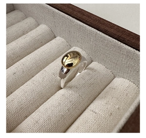 Close-up of S925 sterling silver ring with gold oval inlay inside a jewelry box