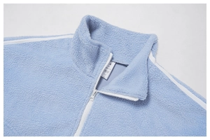Detail of light blue fleece jacket showing stand collar, white zipper and S size tag