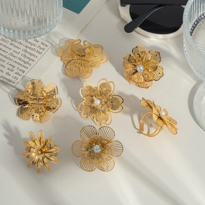 Chic 18K gold-plated hollow camellia rings set with pearls and rhinestones on aesthetic background