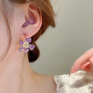 Elegant C-shaped flower earrings with purple crystals and pearl accents in golden finish