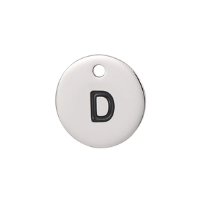 Macro shot of silver titanium steel round pendant with engraved letter D detailing