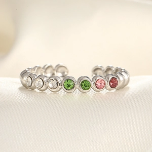 Adjustable silver ring with multi-color zircon stones on a silk fabric background
