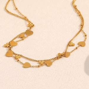 Détail du collier double rang plaqué or 18K avec pendentifs coeurs et perles dorées