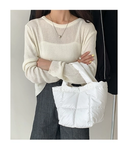 Minimalist white quilted puffer handbag styled with an off-white knit sweater on model
