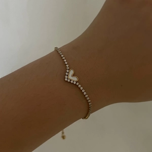 Detail of adjustable gold heart bracelet with white mother of pearl and pavé crystals