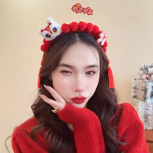 Close-up of red Chinese New Year headband with lion dance doll and hanging tassels