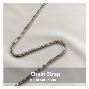 Close-up of bright silver metal chain strap with a dense woven texture for handbags