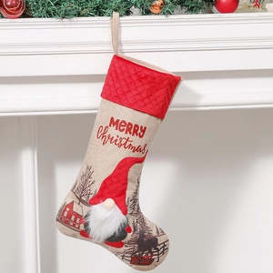 Christmas stocking with red gnome and Merry Christmas text hanging on white fireplace