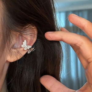 Detail of silver butterfly ear cuff with micro-paved zircons on a model's ear