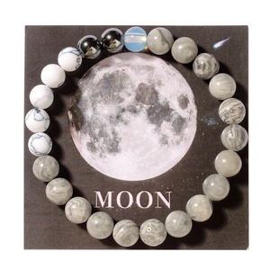 Detailed top view of the universe planet bracelet on a decorative moon theme card
