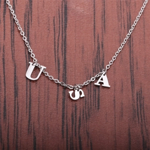 Collier en acier inoxydable avec pendentifs lettres USA sur fond en bois rustique