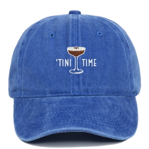 Detailed view of TINI TIME cocktail embroidery on a washed navy blue cotton baseball cap