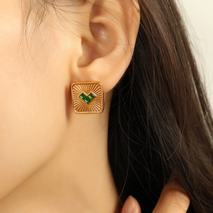 Gold square stud earrings featuring green gemstones and a textured sunburst pattern