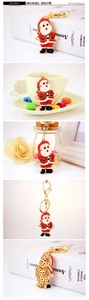 Detail of Santa Claus keychain with red and white rhinestones on a gold metal base