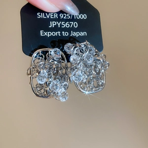 Detailed view of silver wire geometric earrings with sparkling crystals and 18k gold plating