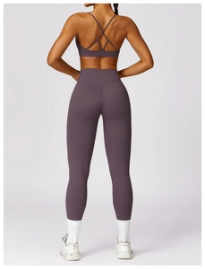 Rear view of high-waist deep purple yoga leggings and matching cross-strap sports bra