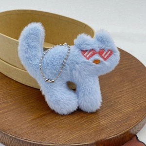 Detail of light blue plush cat brooch with heart sunglasses and silver bead chain