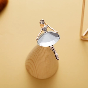 Macro view of gold ballet dancer brooch with large crystal skirt on wooden stand