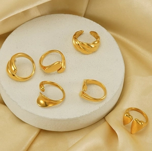 Detailansicht von sechs vergoldeten minimalistischen Ringen auf einem weißen Steinständer