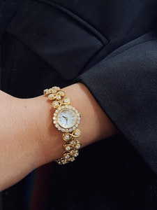 Detailed view of luxury gold vintage watch with diamond-studded bracelet and round dial