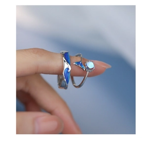 Close-up of S925 silver wave ring and whale tail design with blue enamel and moonstone