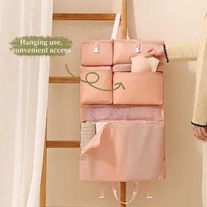 Pink hanging travel organizer bag with multi-layer mesh pockets and secure buckle straps