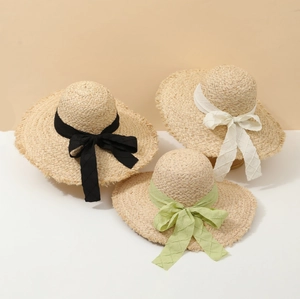 Summer woven straw sun hat with wide brim and decorative ribbon bows for beach vacation