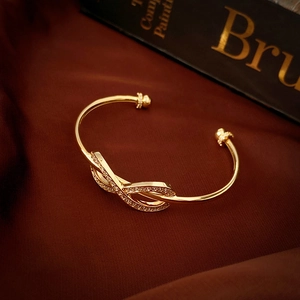 Elegant gold-plated infinity zircon open bangle with sparkling stones on red silk