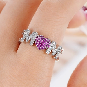 Macro detail of the MOM letter ring with a pink heart gemstone and silver plating