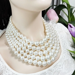 Close-up of five-layer graduated white pearl necklace with glossy finish on a model