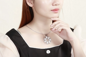 Close-up of elegant silver necklace with pearl pendant and crystals on model's neck