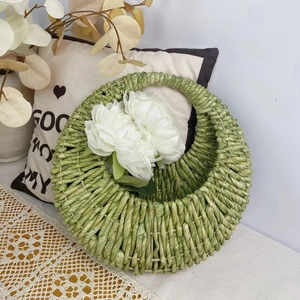 Detail of green woven wall basket with natural plant fiber texture and peony decor