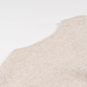 Detailed close-up of beige knit sweater neckline showing premium fine stitching and texture