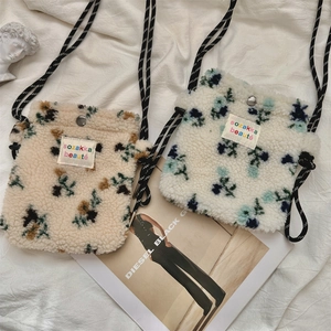 Dettaglio borsa a tracolla floreale in peluche con trama in lana di agnello