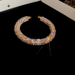 Macro view of rose gold plated open bangle featuring full pavé set rhinestones