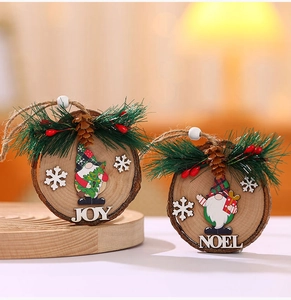 Detail of wooden Christmas ornaments with pine needles, berries and JOY NOEL lettering