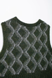 Détail de la texture pelucheuse et du motif losanges du gilet en maille vert foncé