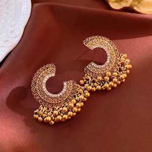 Golden vintage floral earrings with rhinestone accents and round beaded tassels