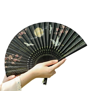 Classic black folding fan featuring golden cranes and pink cherry blossoms held by hands