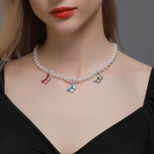 Elegant pearl necklace featuring colorful enamel butterfly pendants on a female model
