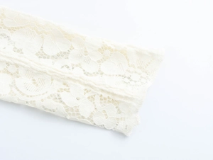 Close-up detail of white floral lace sleeves on a slim fit French style elegant dress