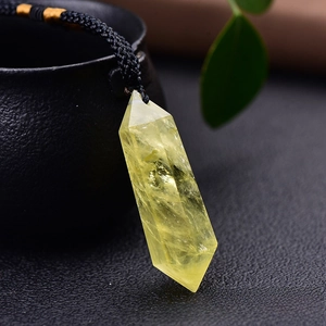 Detailed close-up of a natural citrine hexagonal prism pendant with a black woven cord